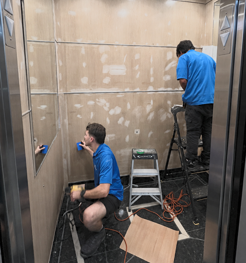 House of Wrap installers preparing an elevator cab for architectural vinyl film