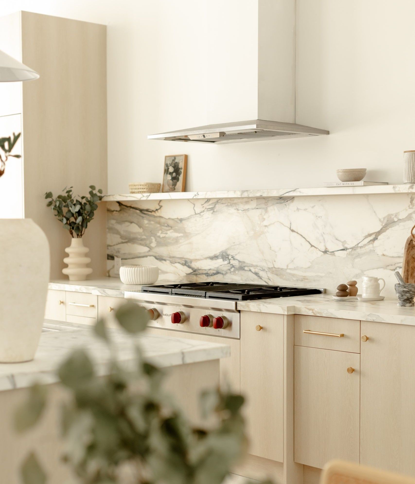 Kitchen cabinet vinyl wrap with light wood finish and marble backsplash