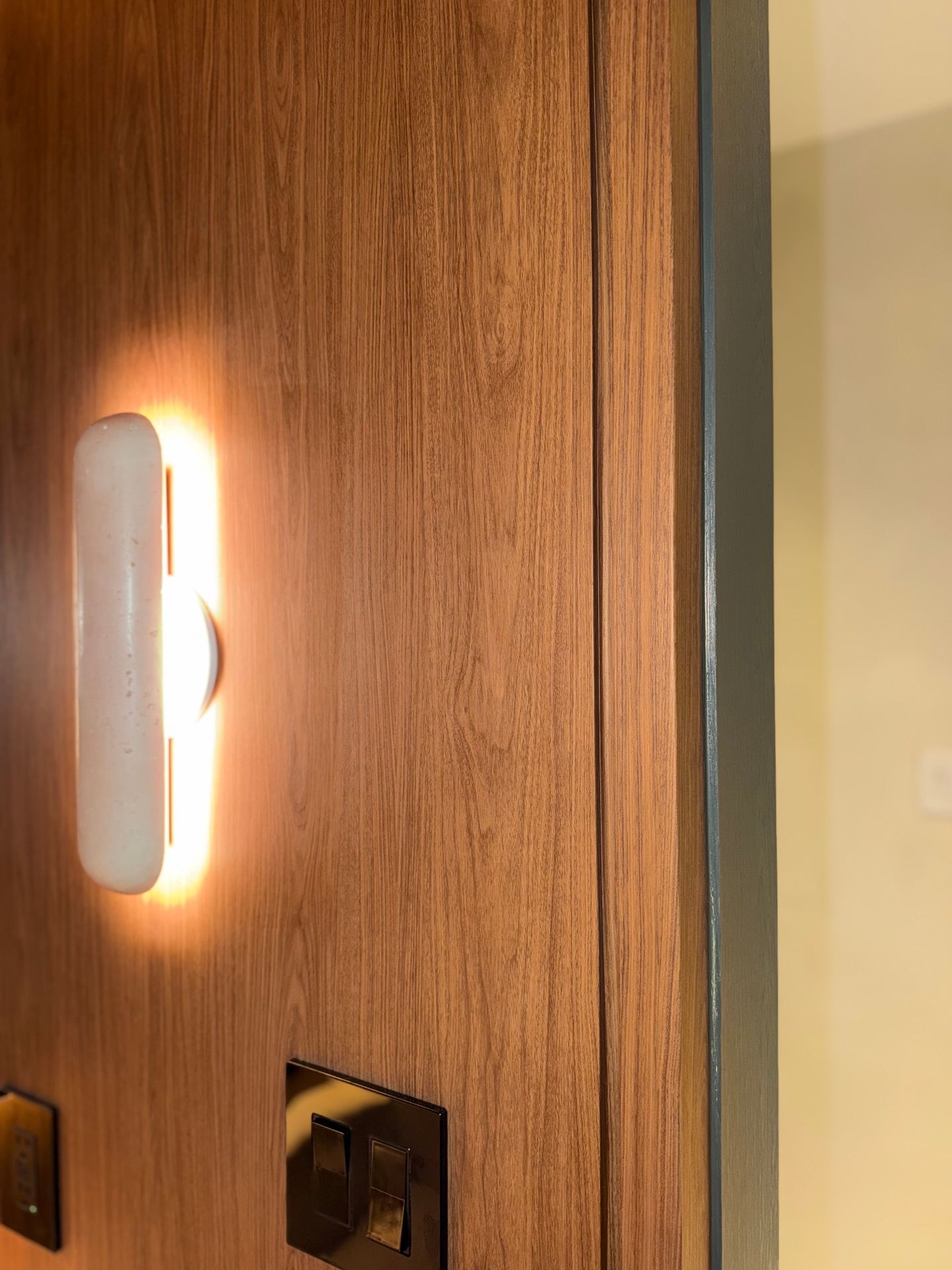 Warm woodgrain wall panel with sconce detail