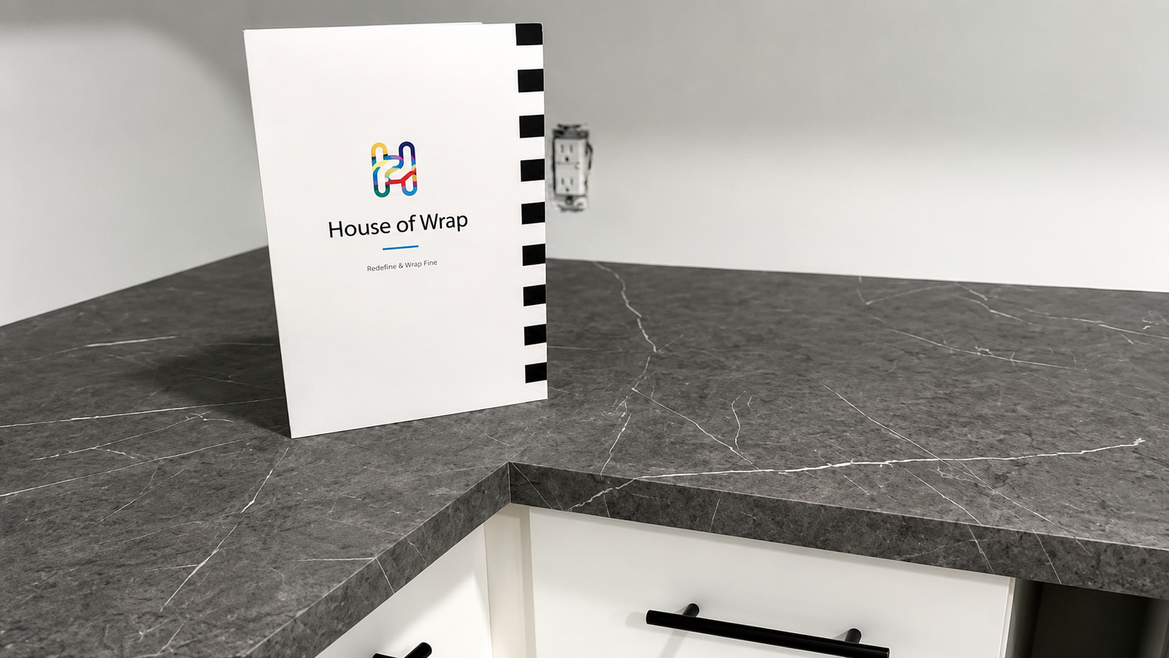 Grey marble vinyl wrapped countertop with House of Wrap sample folder