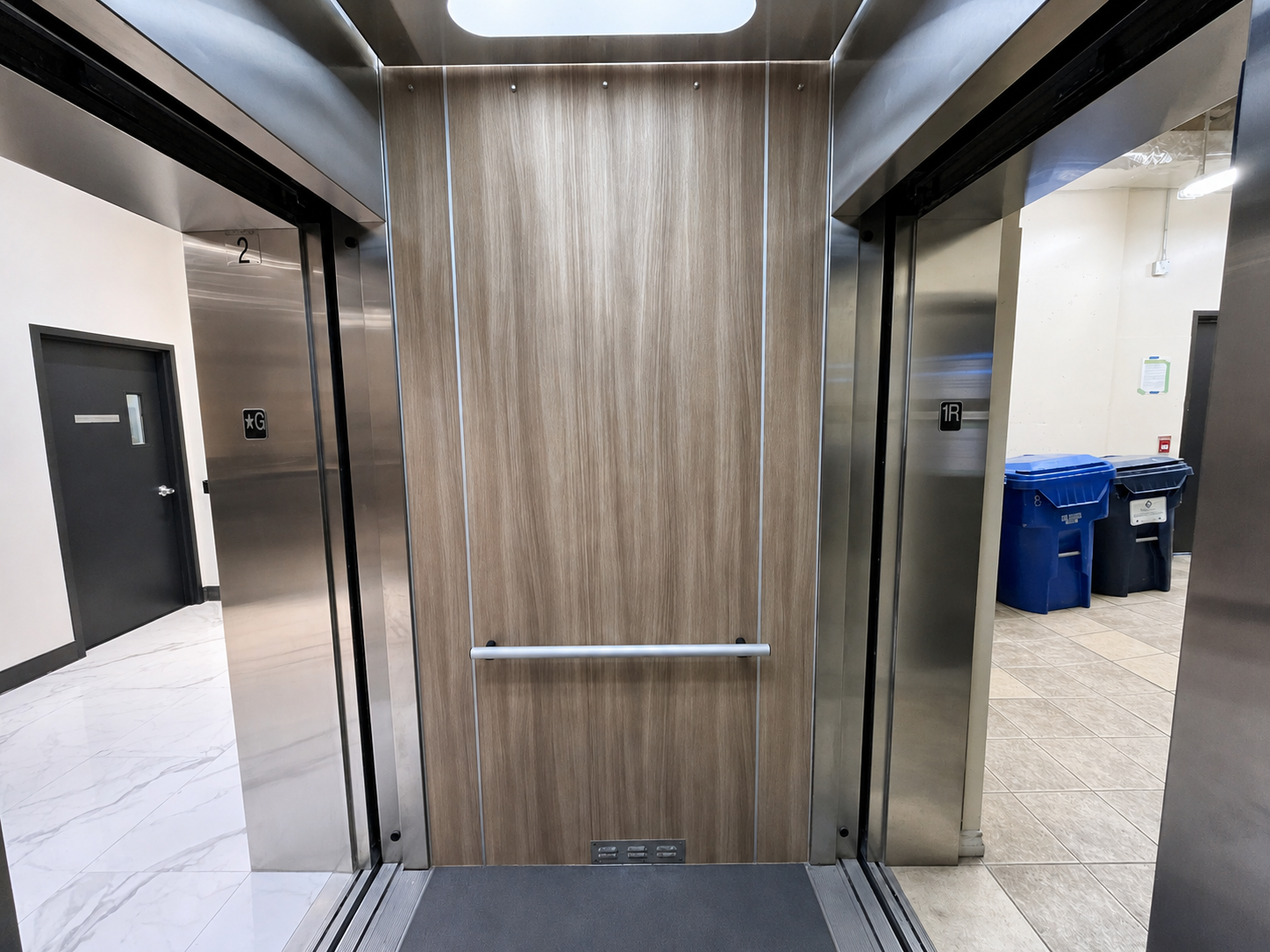 Close-up detail of wood grain vinyl wrap on elevator cab wall