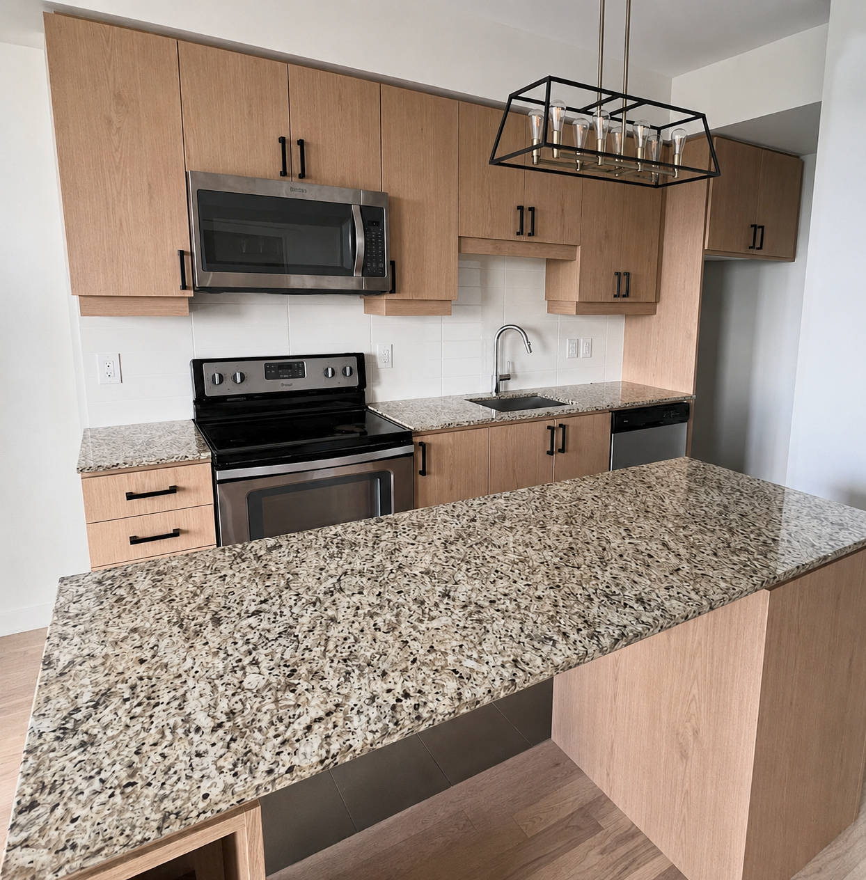 Light oak vinyl-wrapped kitchen cabinets with granite counter