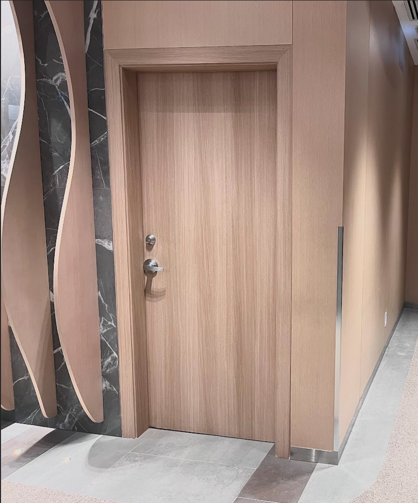 Light woodgrain vinyl-wrapped door with marble accent wall