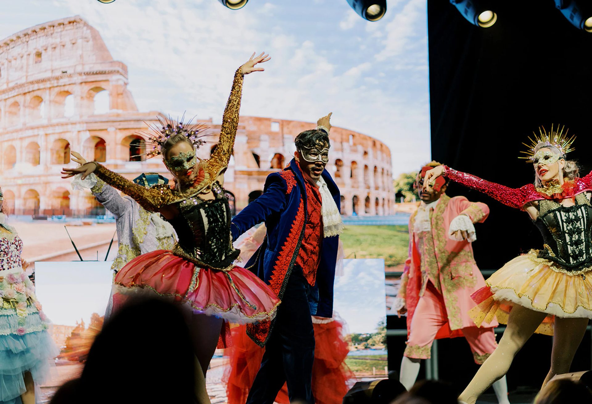 Dancers performing in front of an illustrated event backdrop