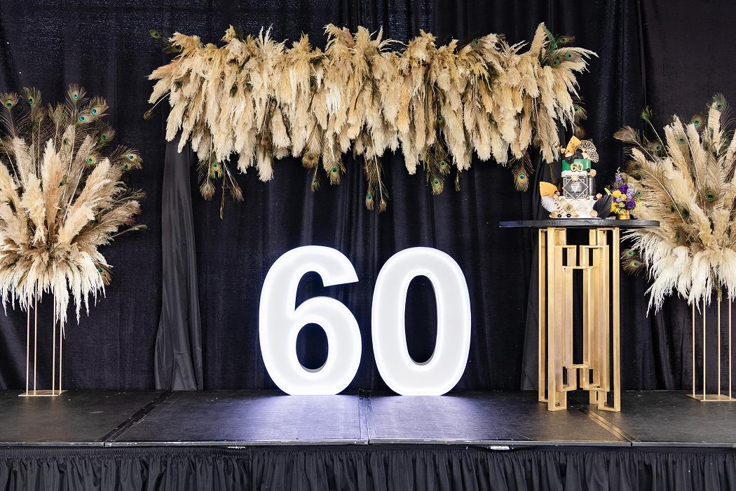Sixtieth birthday milestone stage with pampas decor