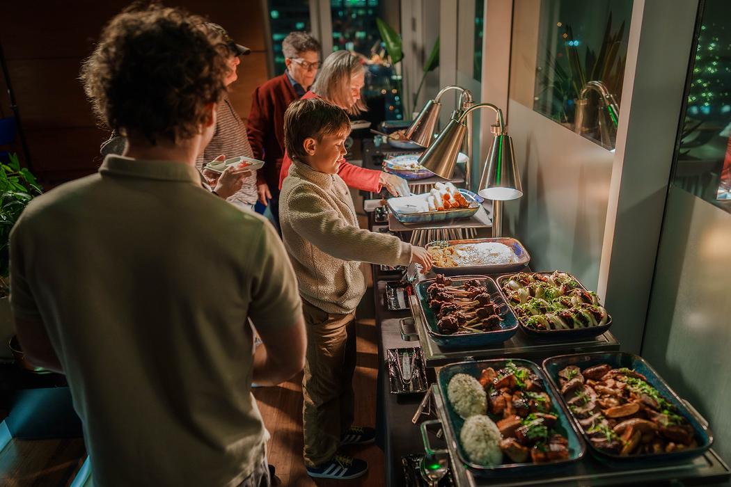 Guests serving food from a buffet station at an event