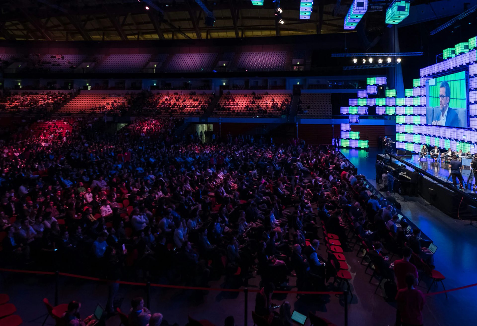 Large conference audience with stage screens