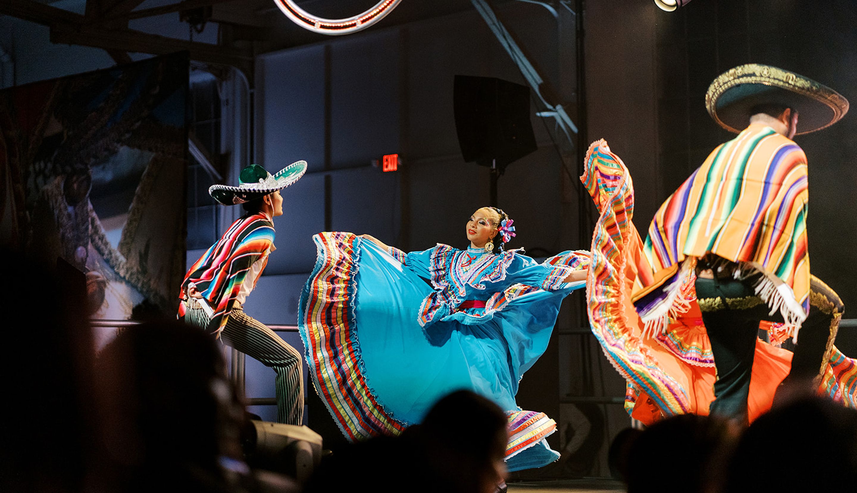 Colorfully dressed dancers performing at a milestone celebration