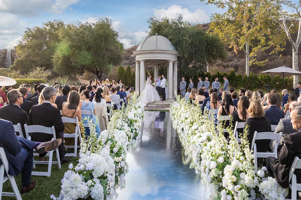 Outdoor wedding ceremony with aisle florals and gazebo