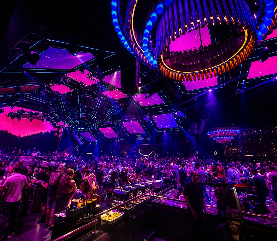 Concert-style event stage with purple lighting and seated guests