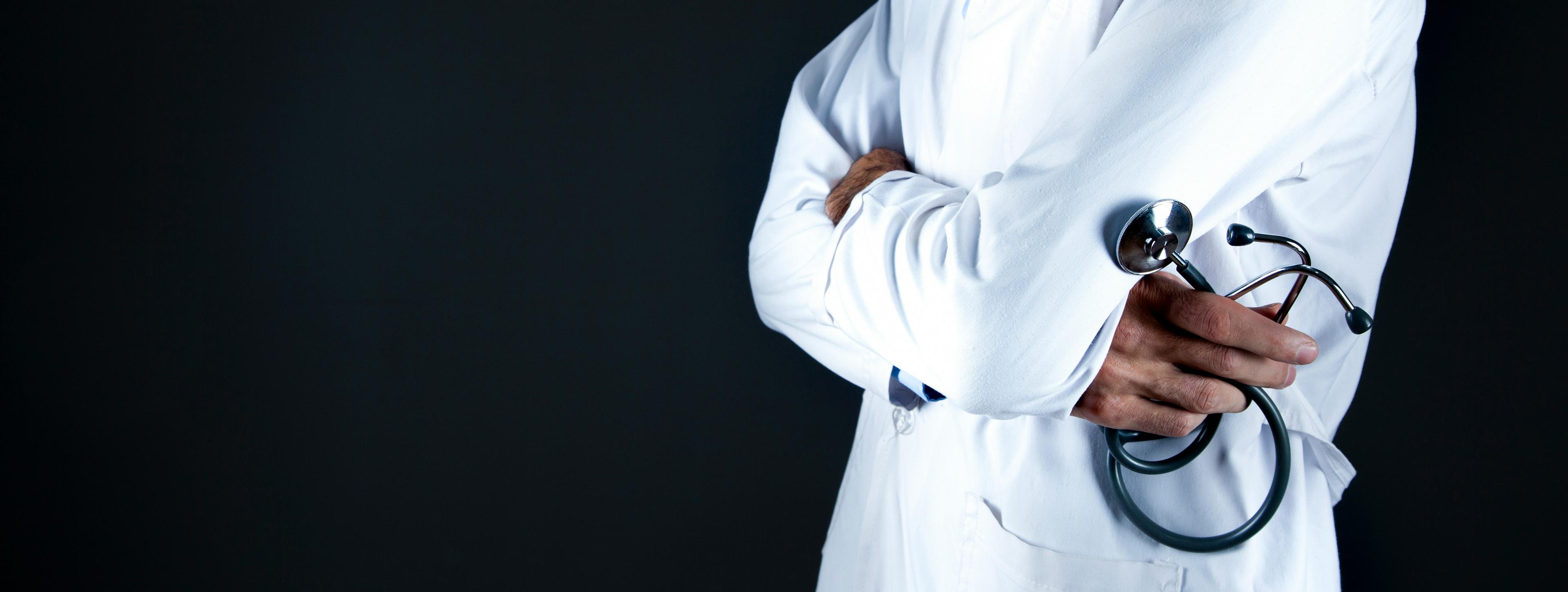 doctor in white coat holding a stethoscope