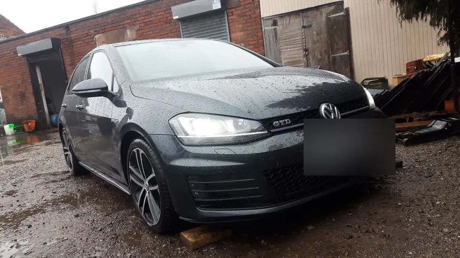 A black VW Golf GTD on gunmetal wheels, on the yard