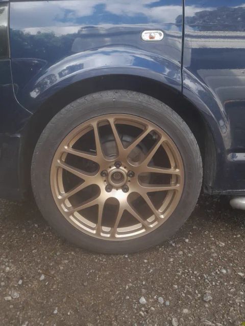 A bronze mesh wheel on a navy van