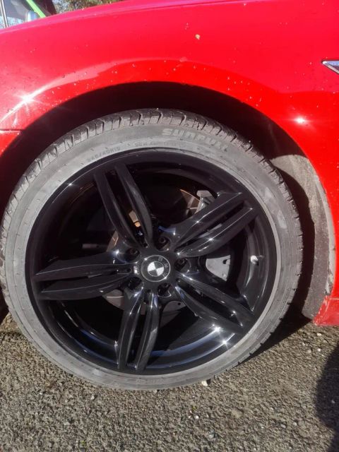 A gloss black BMW wheel on a red BMW 6 Series convertible