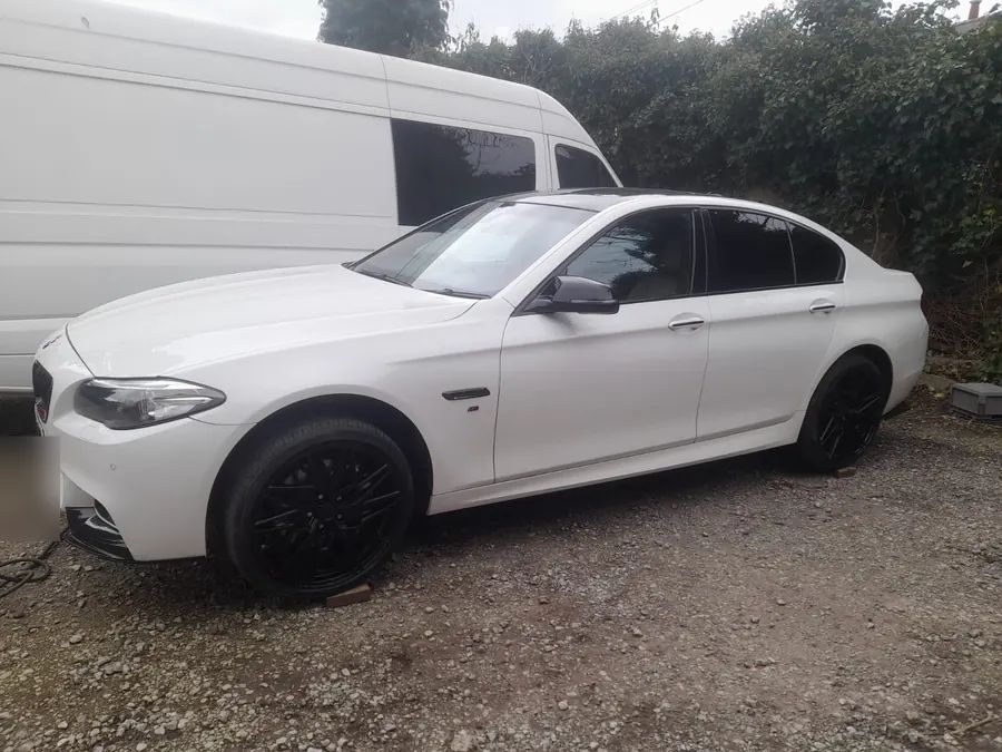 A white BMW saloon on black wheels, on the yard