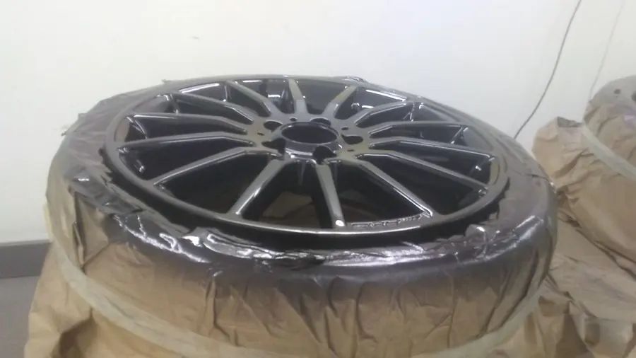 A wheel masked in brown paper in the white spray booth