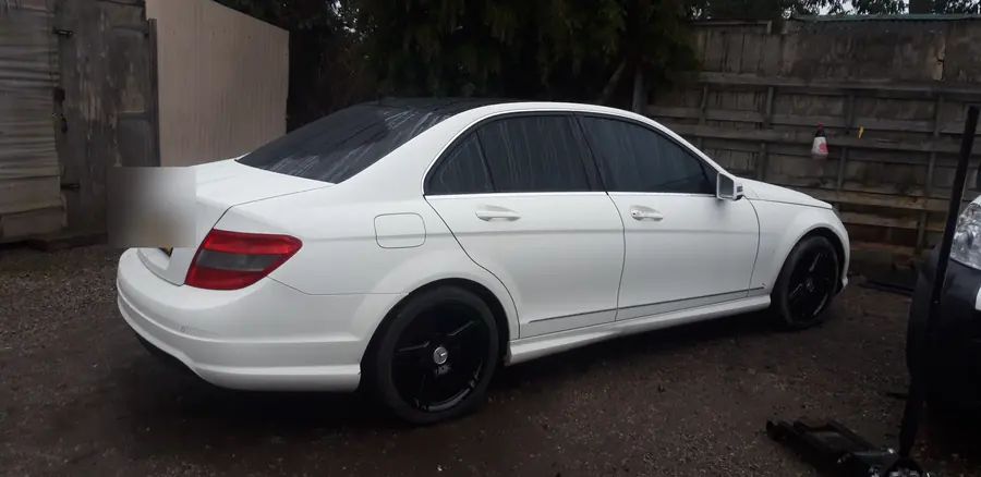 A white Mercedes C-Class saloon on gloss black wheels