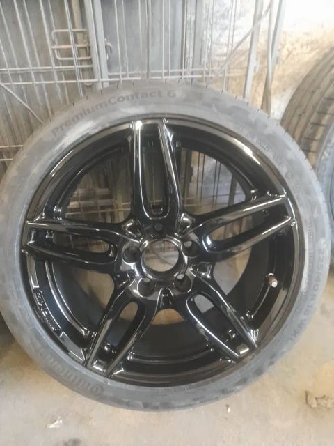 A gloss black Mercedes-AMG five-spoke wheel, off the car
