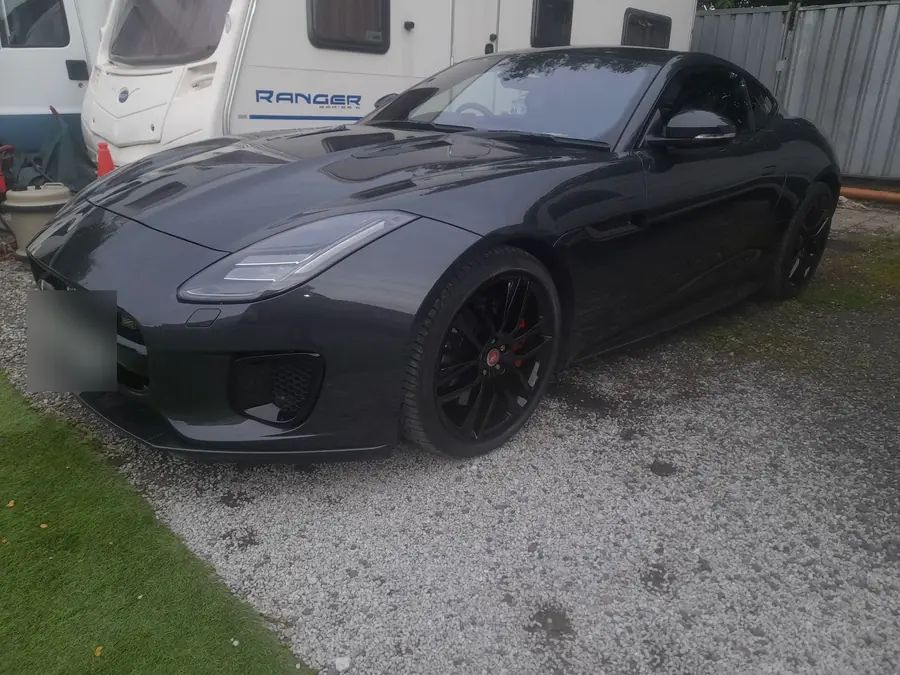 A dark grey Jaguar F-Type on gloss black wheels