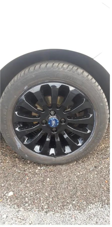 A gloss black Ford wheel with a blue Ford centre cap