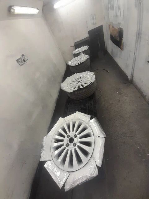 Wheels masked in white paper in the spray booth