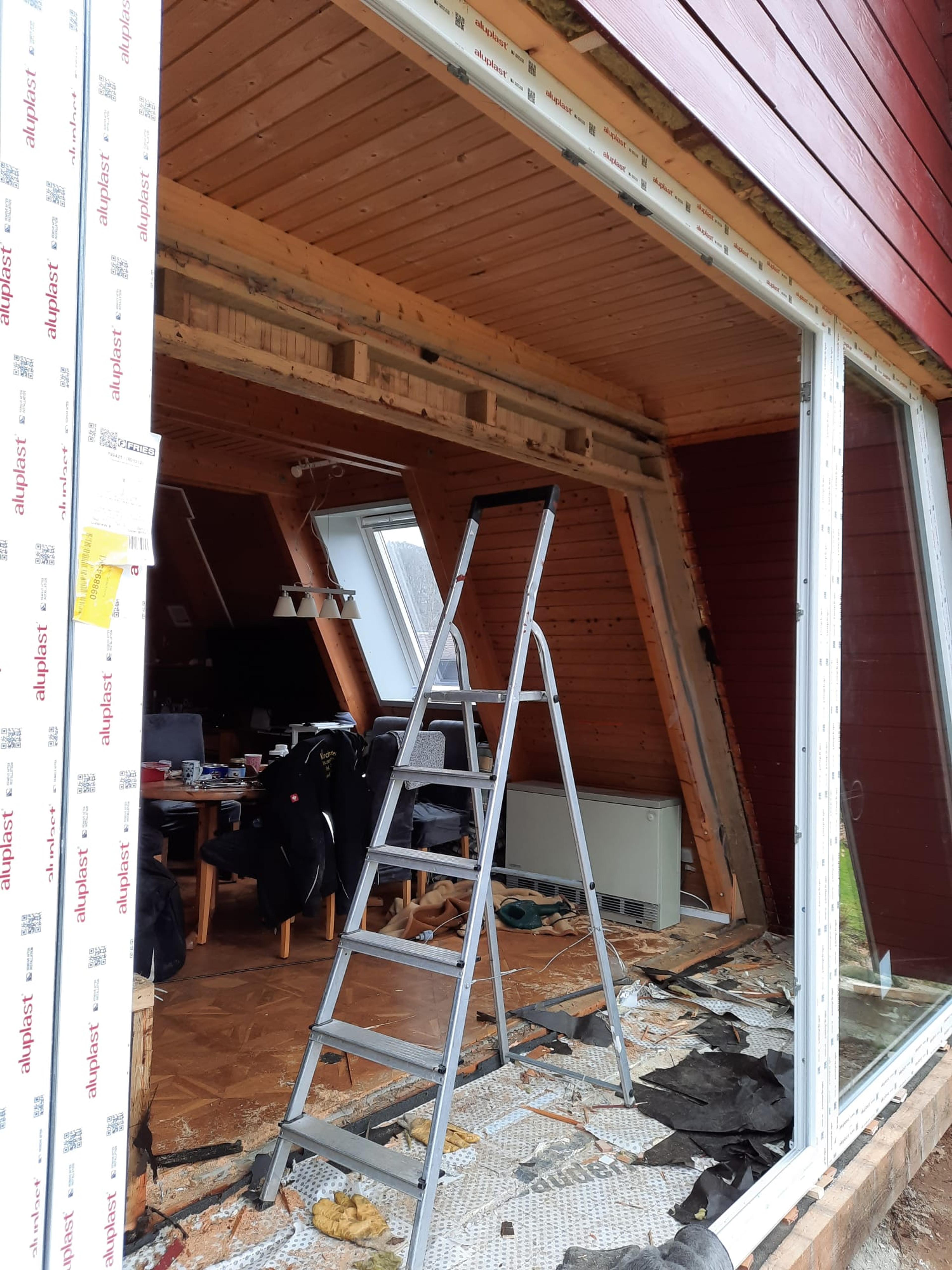 Innenraum eines renovierten Hauses mit neuer Fensteröffnung und Leiter