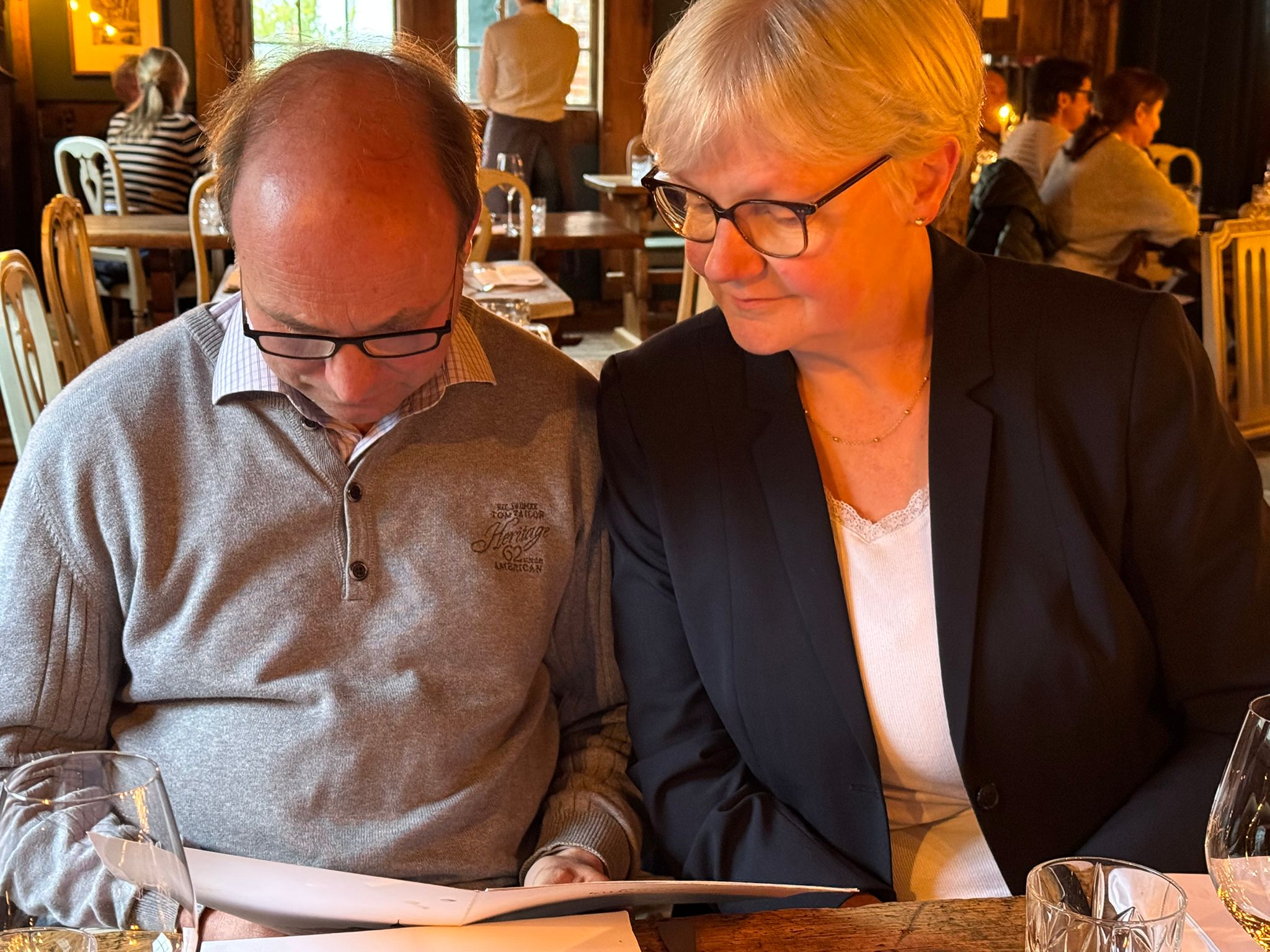 Mann und Frau schauen zusammen in ein Dokument in einem gemütlichen Restaurant