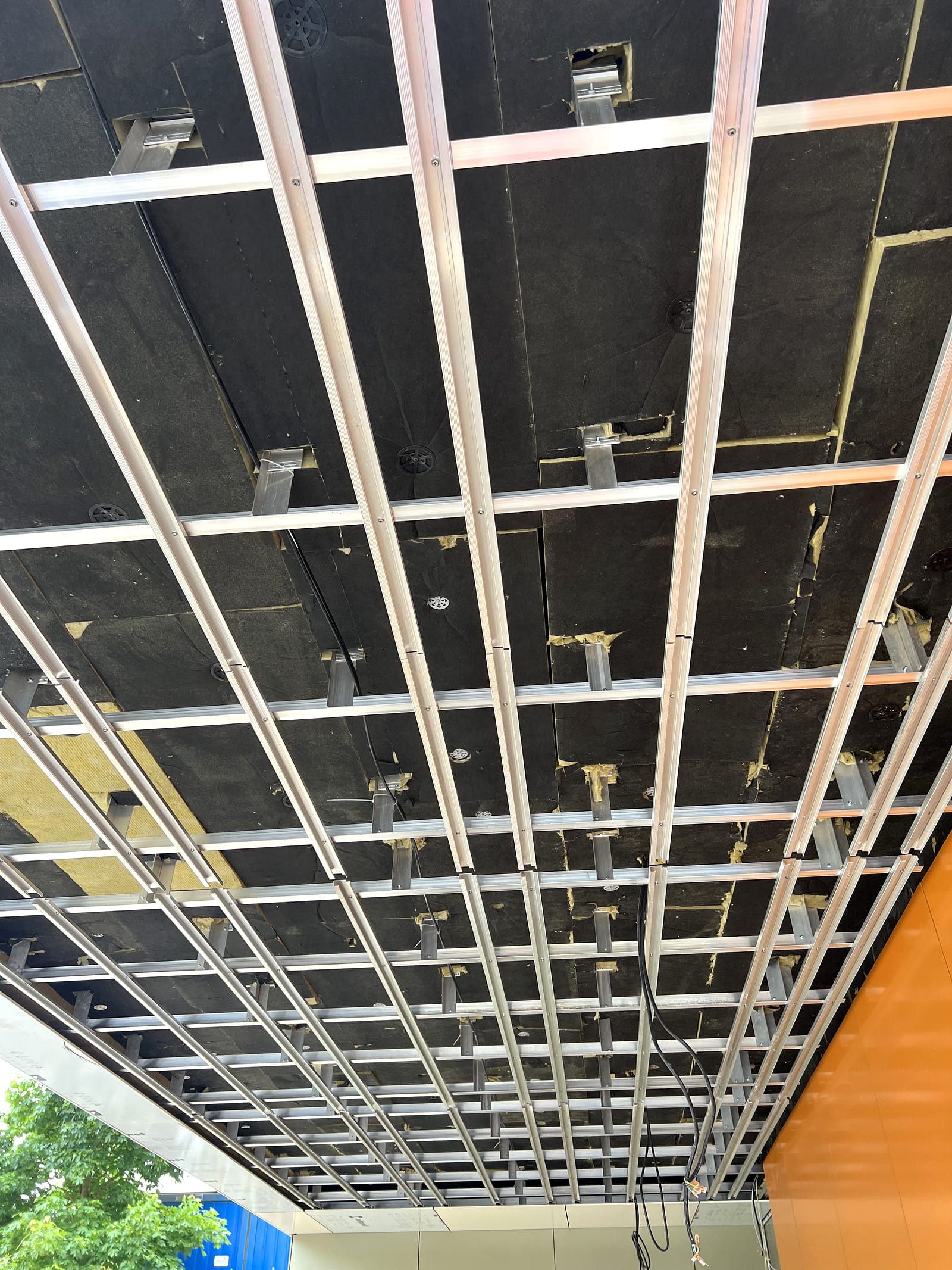 Pose en cours du plafond Rockpanel sous l'auvent — équipe Schnür Systeme à l'ouvrage