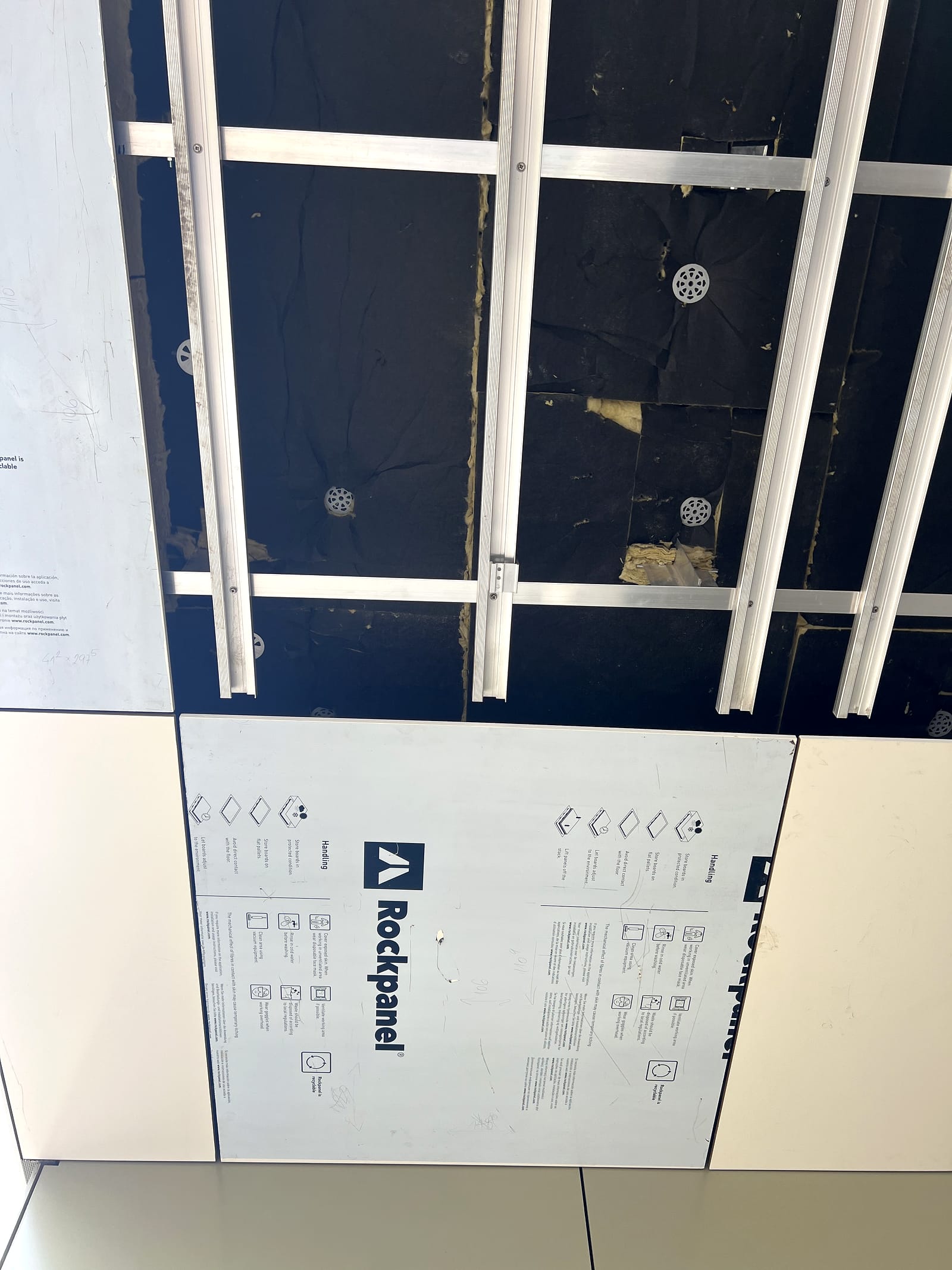 Panneau Rockpanel grandes dimensions en cours de pose en plafond suspendu
