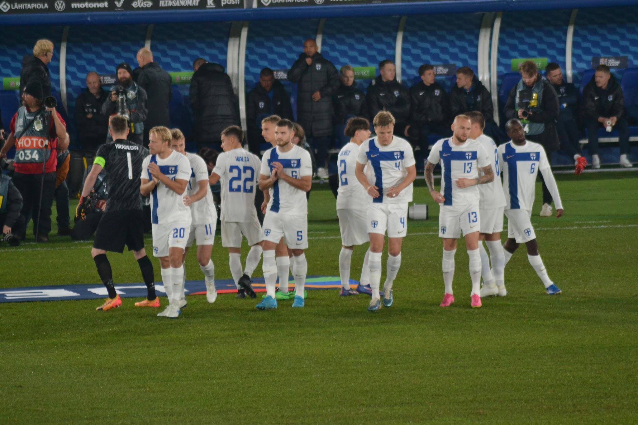 Suomen pelaajat kentällä vaihtopenkin edessä ennen Suomi–Irlanti-ottelua, maalivahdin paidassa Hradecky 1