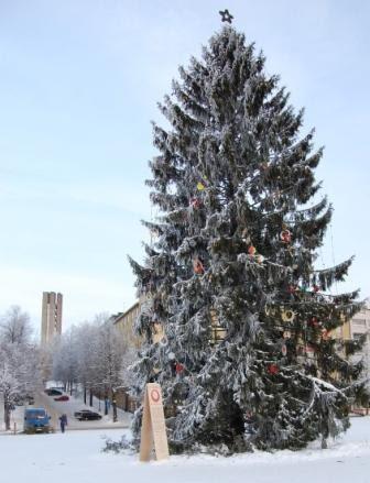 Huurteinen joulukuusi lumisella torilla talvipäivänä, taustalla kirkontorni, 24.12.2010