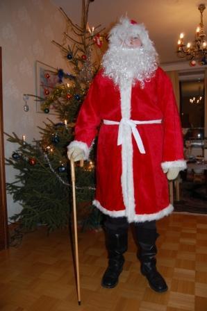 Joulupukki punaisessa asussa kävelykeppi kädessä koristellun joulukuusen vieressä, 24.12.2011