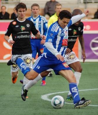 Litmanen HJK:n sinivalkoisessa paidassa numero 10 potkaisee palloa vastustajien keskellä, 29.10.2011