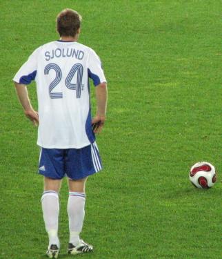 Suomen pelaaja valkoisessa pelipaidassa numero 24 ja nimi Sjolund seisoo kentällä pallon vieressä, 12.09.2007