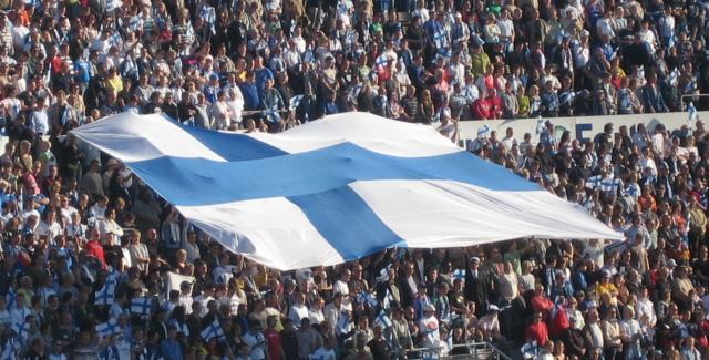 Suuri Suomen lippu levitettynä katsomon yllä täydessä, pikkulippuja heiluttavassa yleisössä, 02.06.2007