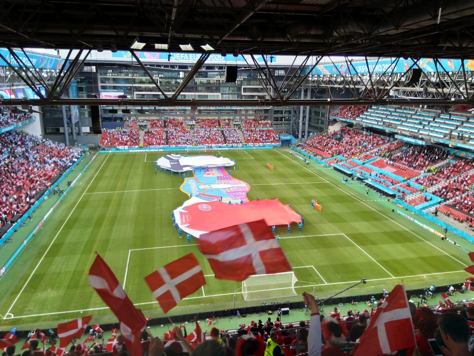 Tanska–Suomi-ottelun avajaisseremonia: kentälle levitetyt jättipelipaidat ja Copenhagen-kangas, katsomossa Tanskan lippuja