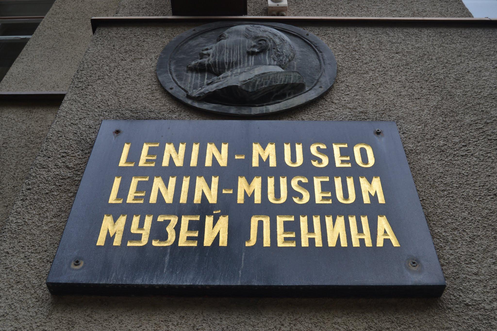 Lenin-museon seinäkyltti kultaisin kirjaimin suomeksi, saksaksi ja venäjäksi, yläpuolella reliefimedaljonki