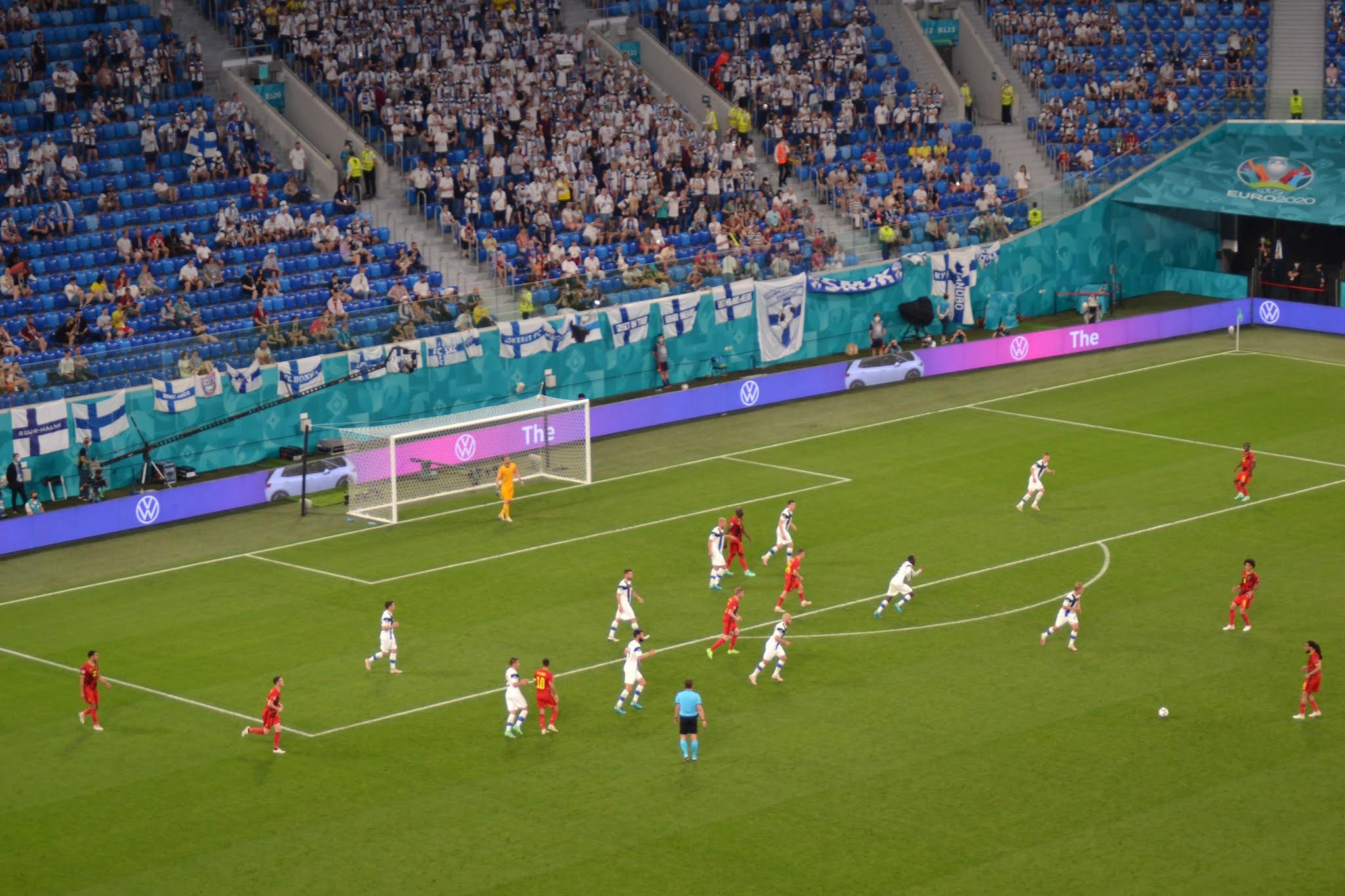 Suomi–Belgia-ottelu käynnissä EURO2020-stadionilla, katsomossa Suomen lippuja ja kannattajia