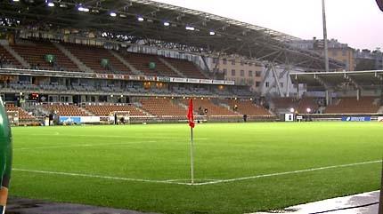 Tyhjä Finnair Stadium ja vihreä nurmi, etualalla punainen kulmalippu