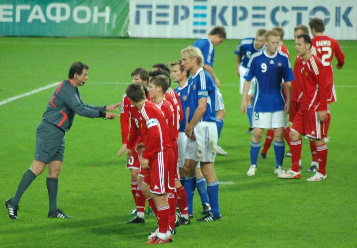 Tuomari ohjeistaa punapaitaisten pelaajien muuria Suomen vapaapotkutilanteessa Moskovassa, 15.10.2008