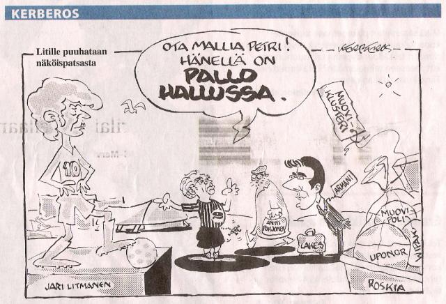 Kerberos-pilapiirros Jari Litmasen näköispatsaasta. Puhekupla: ”Ota mallia Petri! Hänellä on pallo hallussa.”