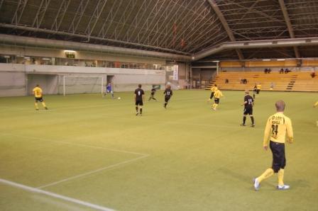 Lahti–KuPS-ottelu Suurhallissa, keltapaitaiset ja mustapaitaiset pelaajat tekonurmella, 27.01.2012