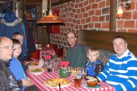 Klubin 5-vuotisjuhlaruokailu Martinassa: seurue punaruudullisen pöydän ääressä tiiliseinäisessä salissa, 04.03.2012