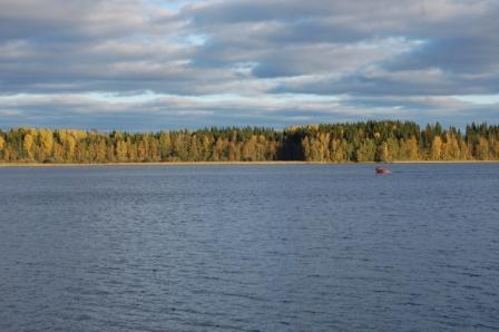 Syksyinen Kymijärvi, rannalla keltaista ja vihreää metsää ja järvellä pieni punainen vene, 01.10.2011