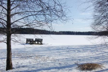 Jäätynyt Kymijärvi ja kaksi penkkiä lumisella rannalla aurinkoisena päivänä, 01.04.2012