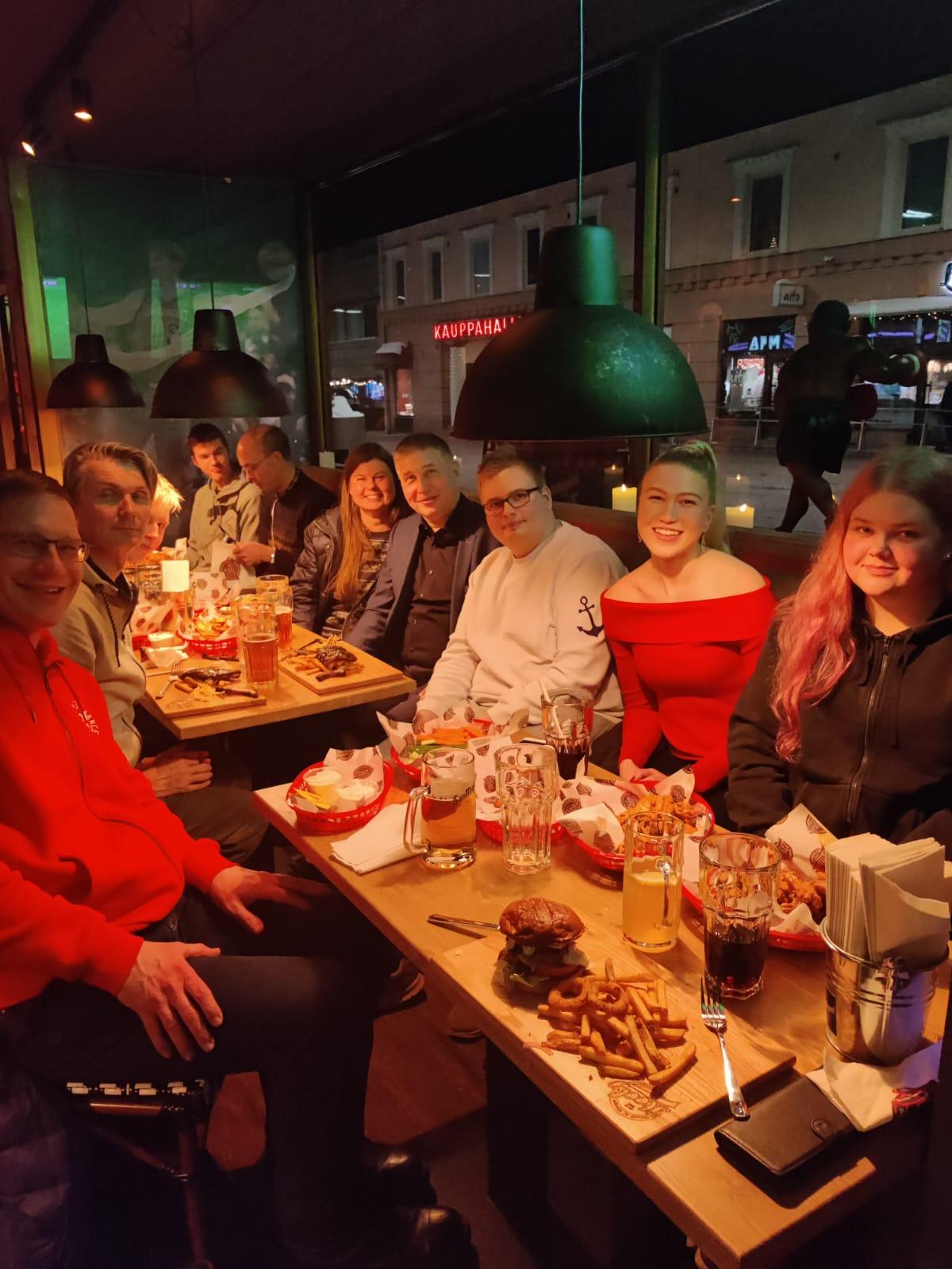 Klubilaisia jouluruokailussa Hook-ravintolassa Lahdessa hampurilaisannosten ääressä, ikkunan takana Kauppahalli-kyltti, 17.12.2022