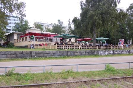 Ravintola Strampenin terassi punaisine ja vihreine aurinkovarjoineen puiden katveessa Vaasassa, 11.08.2012