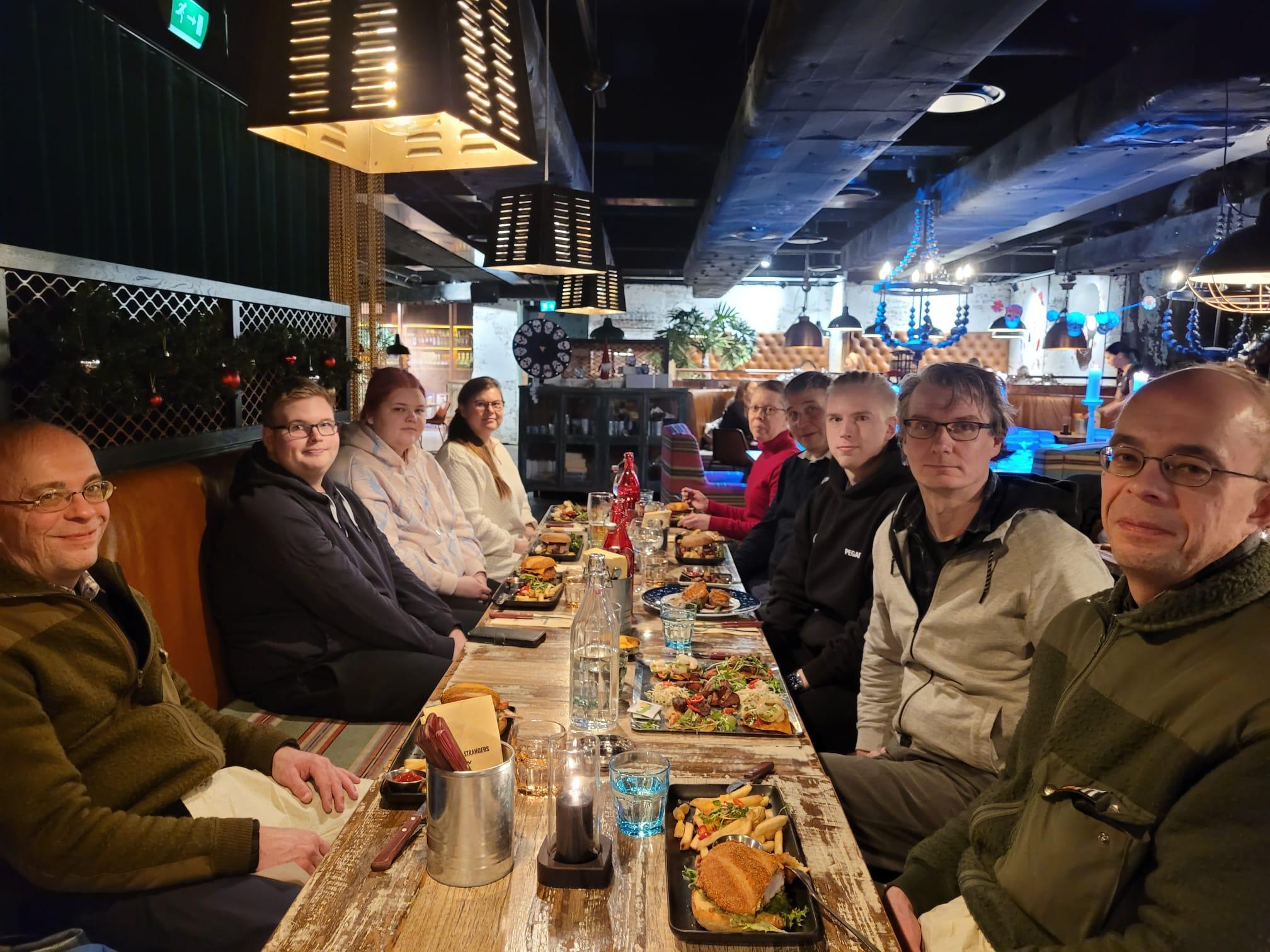 Klubilaiset jouluruokailulla Amarillossa pitkän pöydän ääressä hampurilais- ja pihviannosten kanssa, 26.12.2023