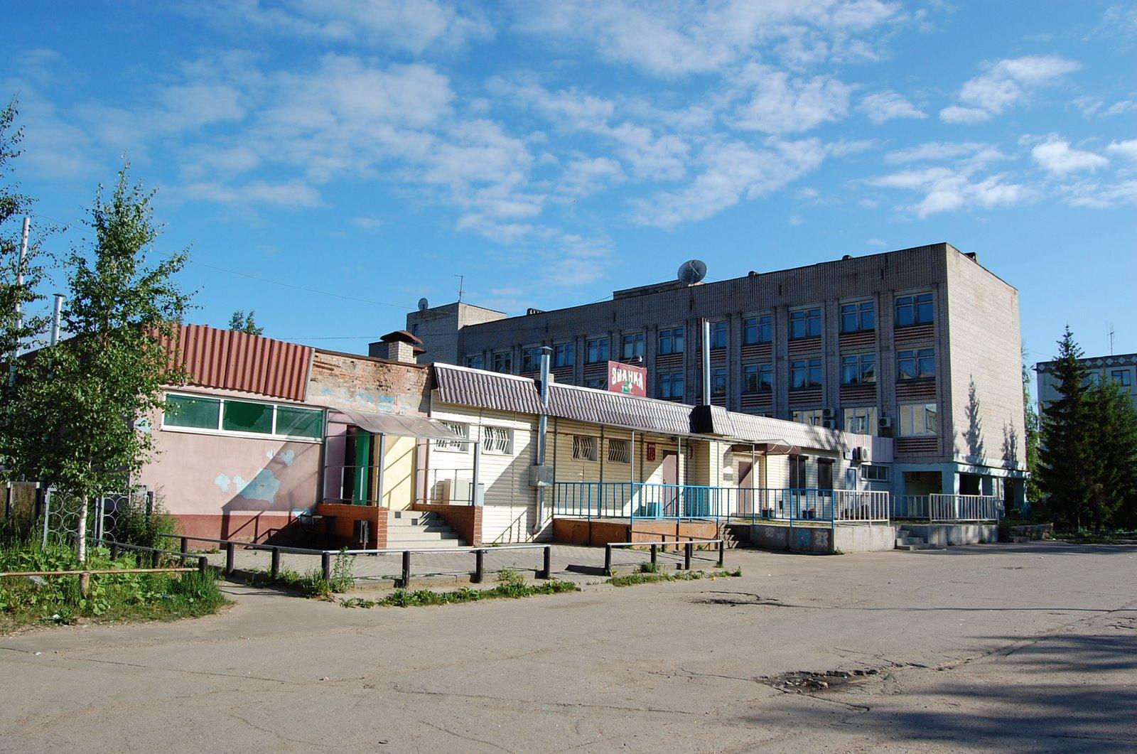 Matalia liikerakennuksia ja nelikerroksinen tiilitalo Chudovossa kesäisen sinitaivaan alla, 06.07.2008