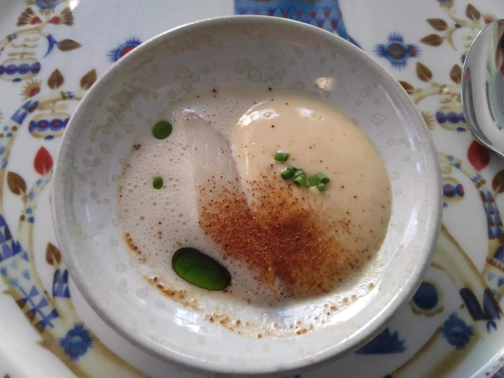 Kermainen keittoannos vihreine öljytippoineen koristeellisella lautasella ravintola C:ssä, 05.09.2019